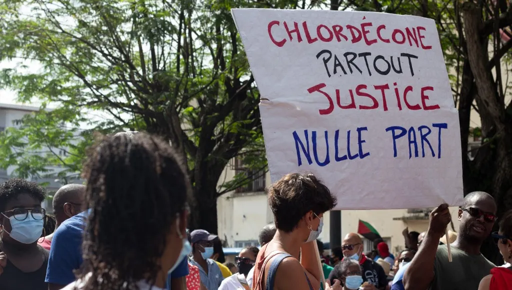 Manifestation chlordécone. Des manifestants brandissent une pancarte avec écrit : "Chlordécone partout, justice nulle part".